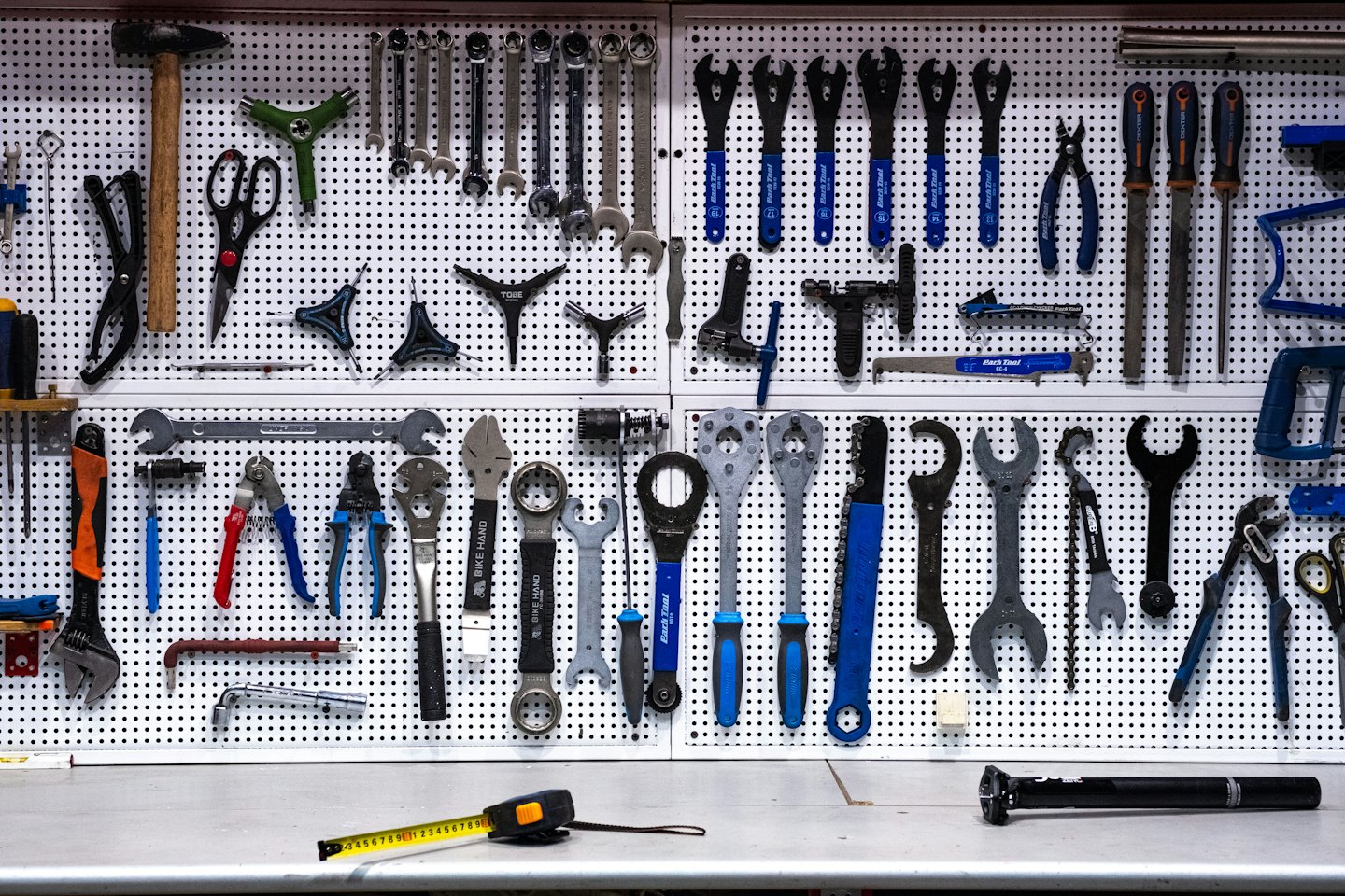 En pegboard visar en organiserad samling cykelreparationsverktyg.