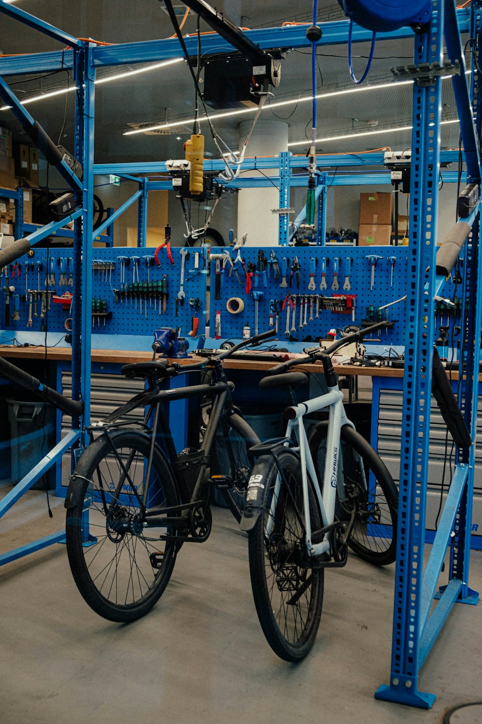 Två cyklar parkerade i en välutrustad cykelverkstad.